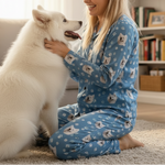 Woman in blue pajamas with a white dog in a living room