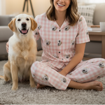 Woman in pink pajamas with dog sitting on floor in living room